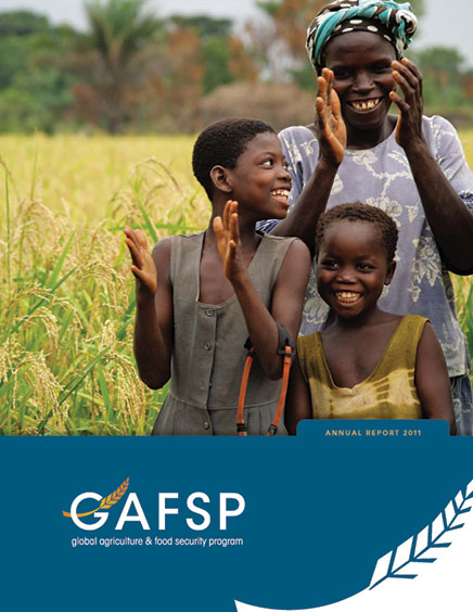 three african women in field clapping hands and smiling